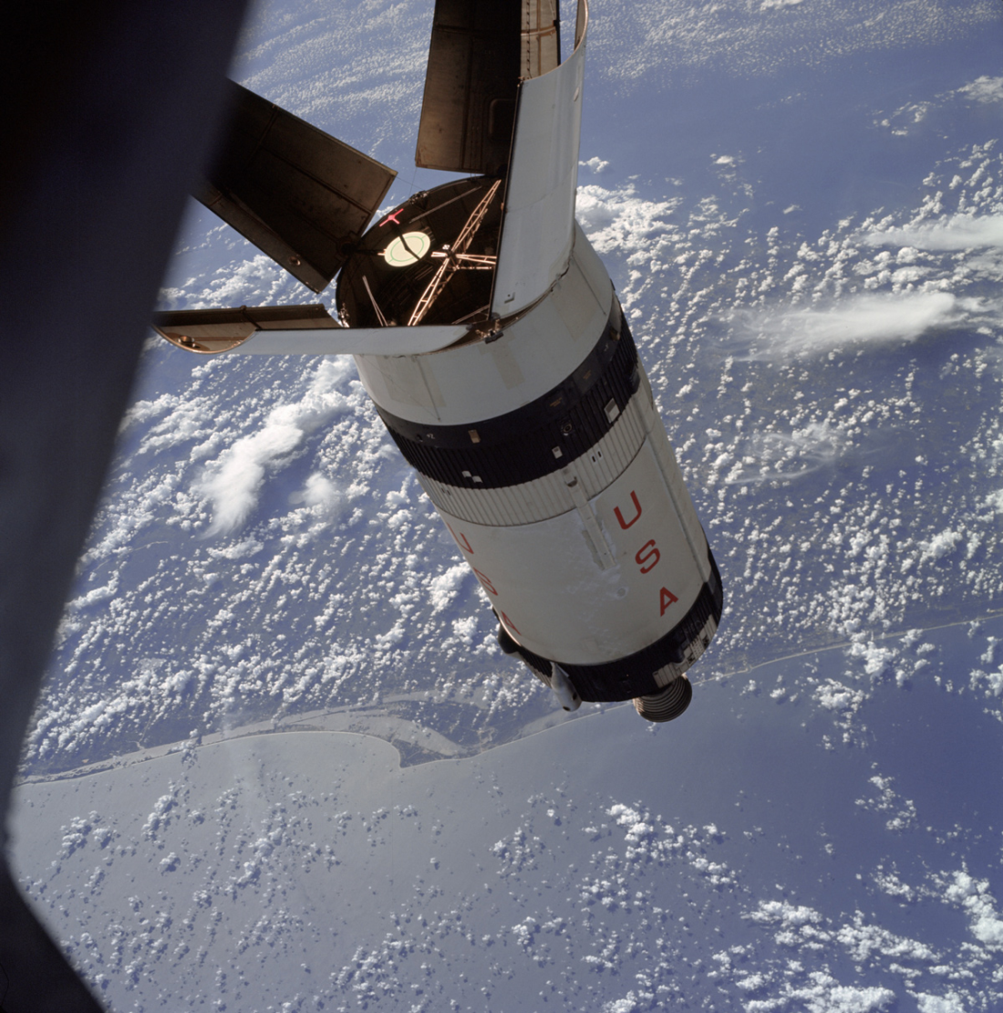 image of the Apollo 7 S-IVB stage over Cape Kennedy, Florida as seen from one of the CSM windows